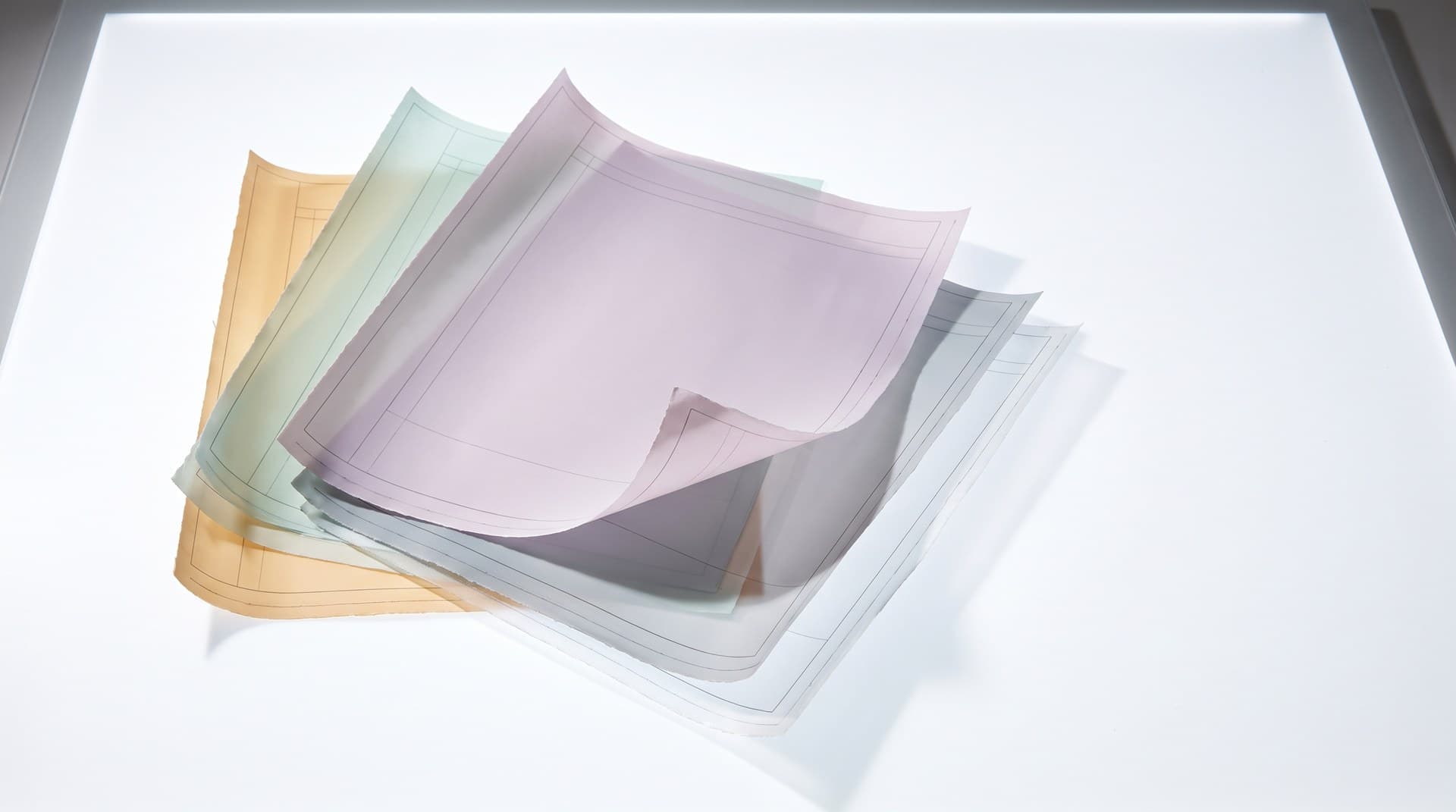 Five translucent drafting overlay sheets in amber, mint, lilac, grey and clear, fanned in an offset stack on a bright white light table, a visual metaphor for Claude Code's stacked instruction layers: output style, CLAUDE.md, appended system prompt and skills