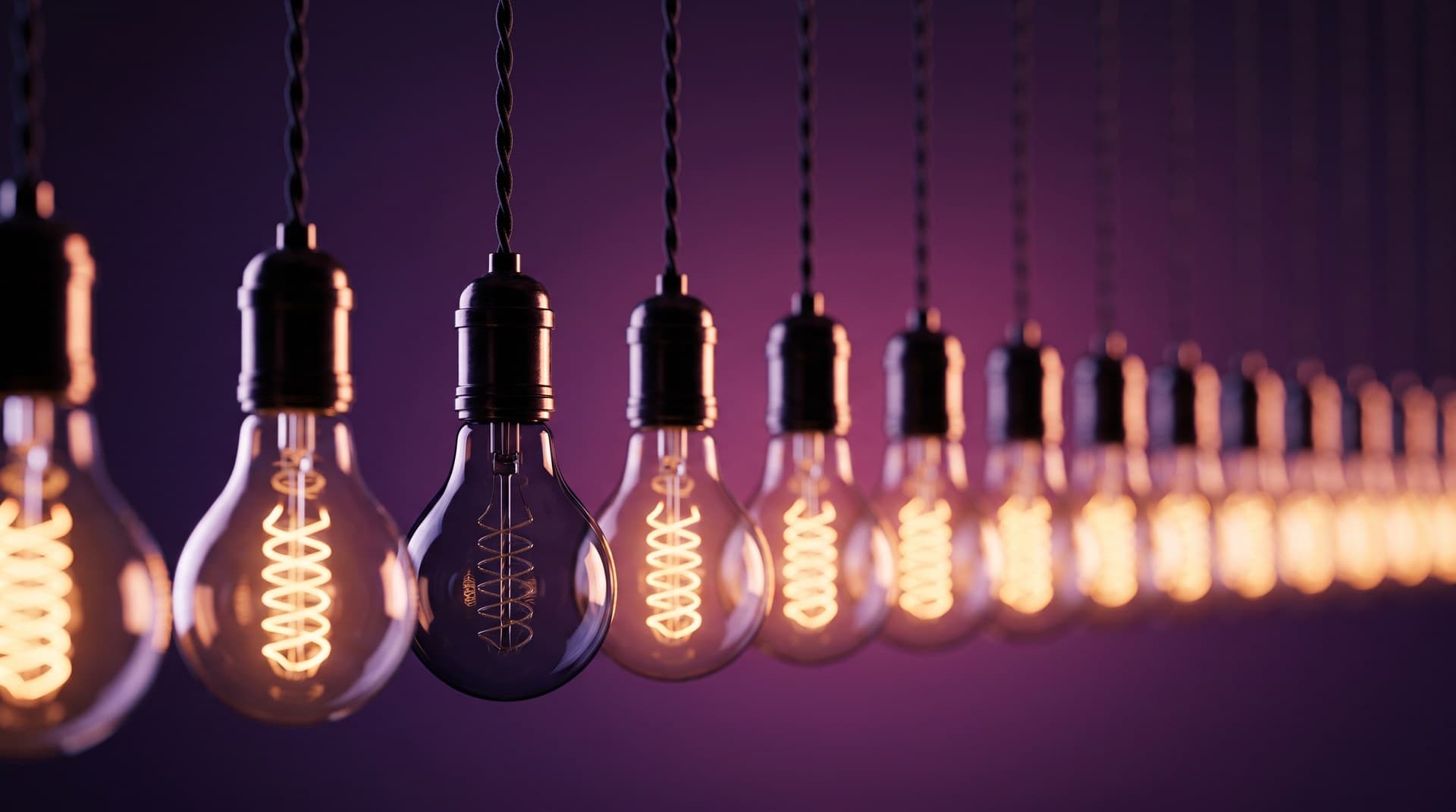 A long row of hanging vintage filament bulbs glowing warm amber against a deep violet background, with one bulb near the center left completely dark and unlit, representing a Claude skill that never gets invoked