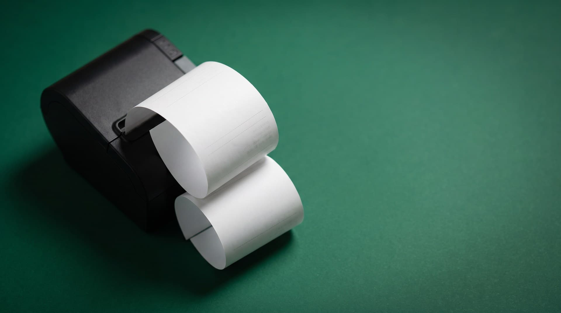 Two identical blank receipts curling out of a black thermal printer on a deep green surface, illustrating a duplicate n8n execution